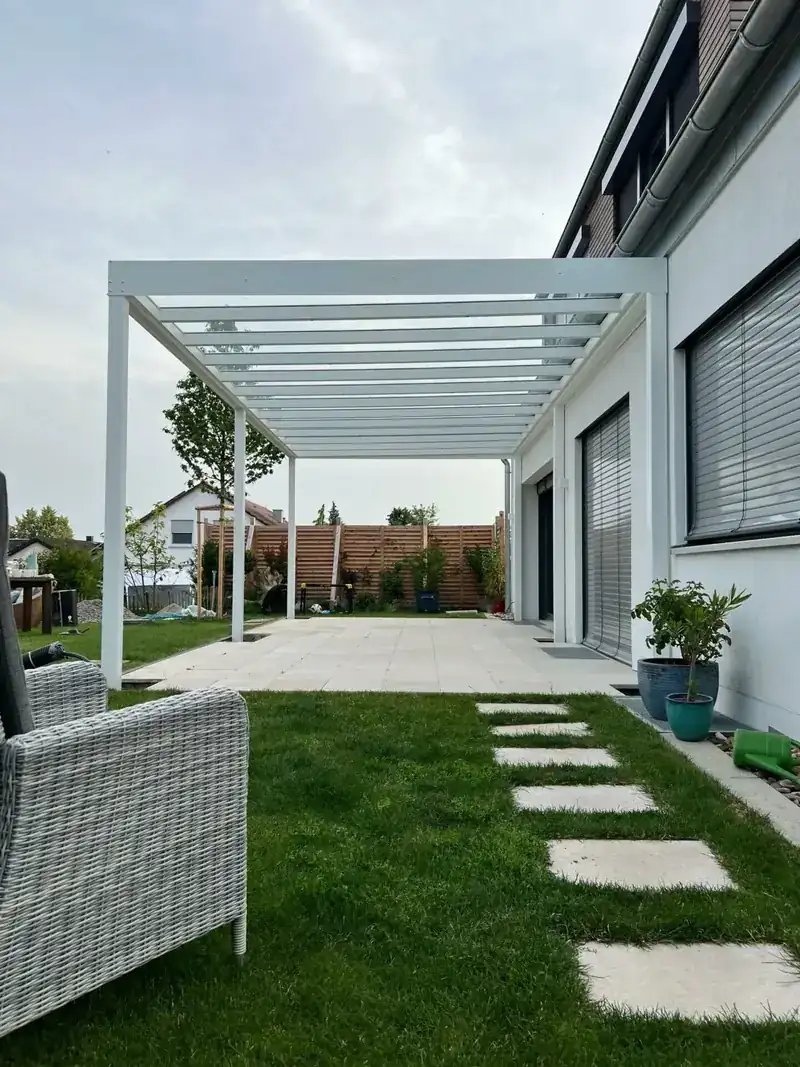 Weiße Terrassenüberdachung über einer Terrasse, gebaut und montiert