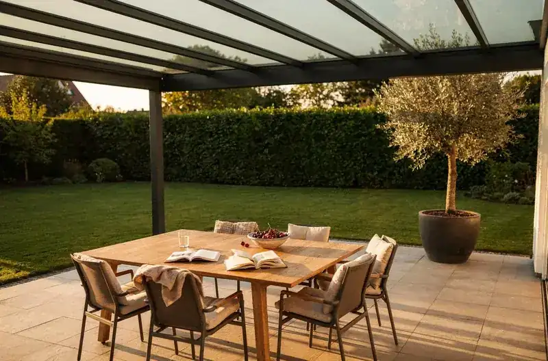 Gedeckter Tisch unter einem Aluminium-Terrassendach im Abendlicht