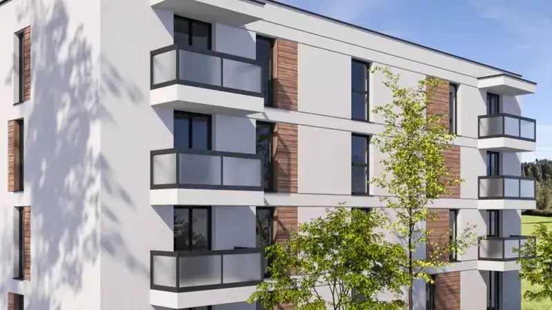 Balkone mit Glasgeländern an einem hellen Wohngebäude